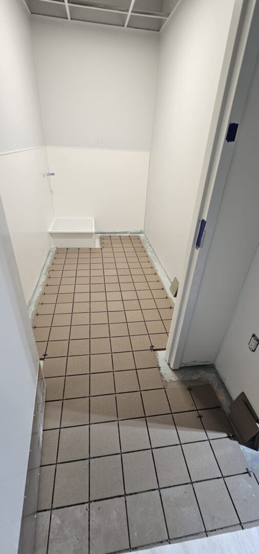 A bathroom with brown tile and white walls.