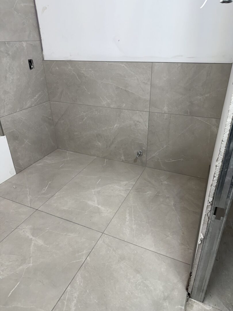 IMG_4538 A bathroom with a large gray tile floor.