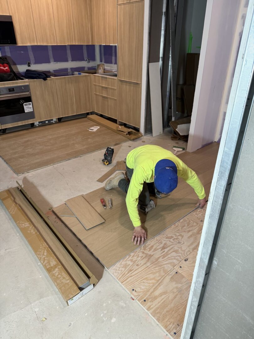 A man laying down on the floor of a kitchen.