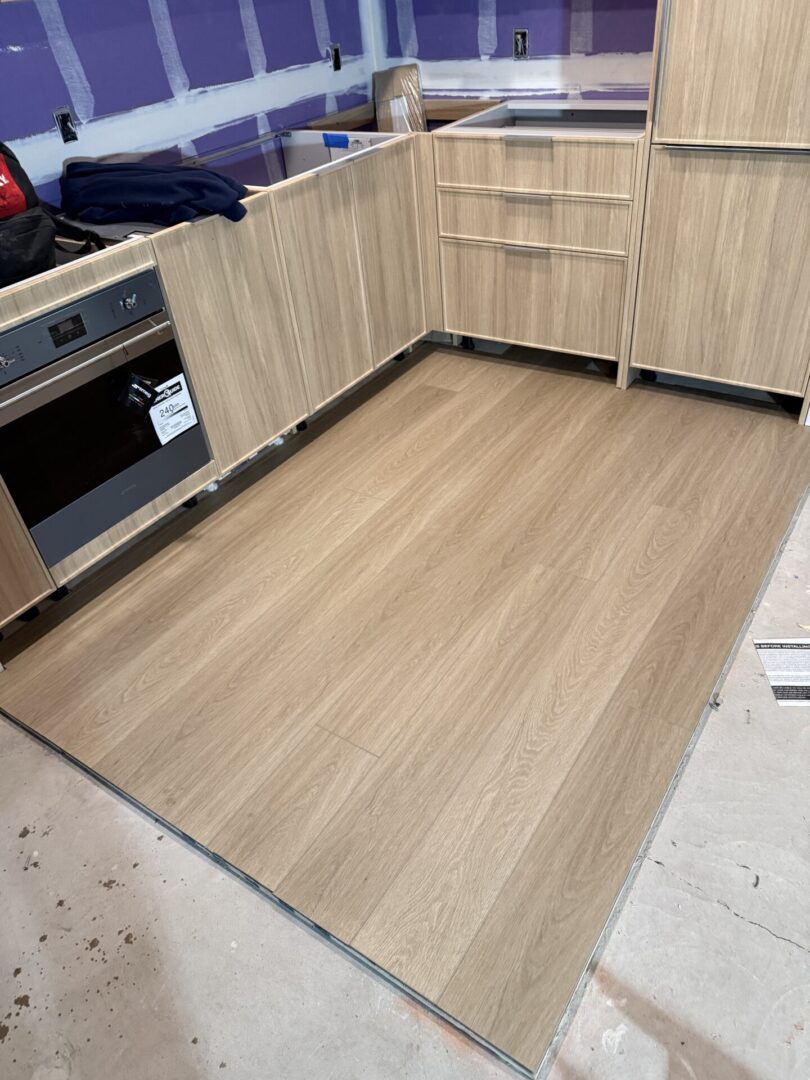 A kitchen with wooden floors and cabinets
