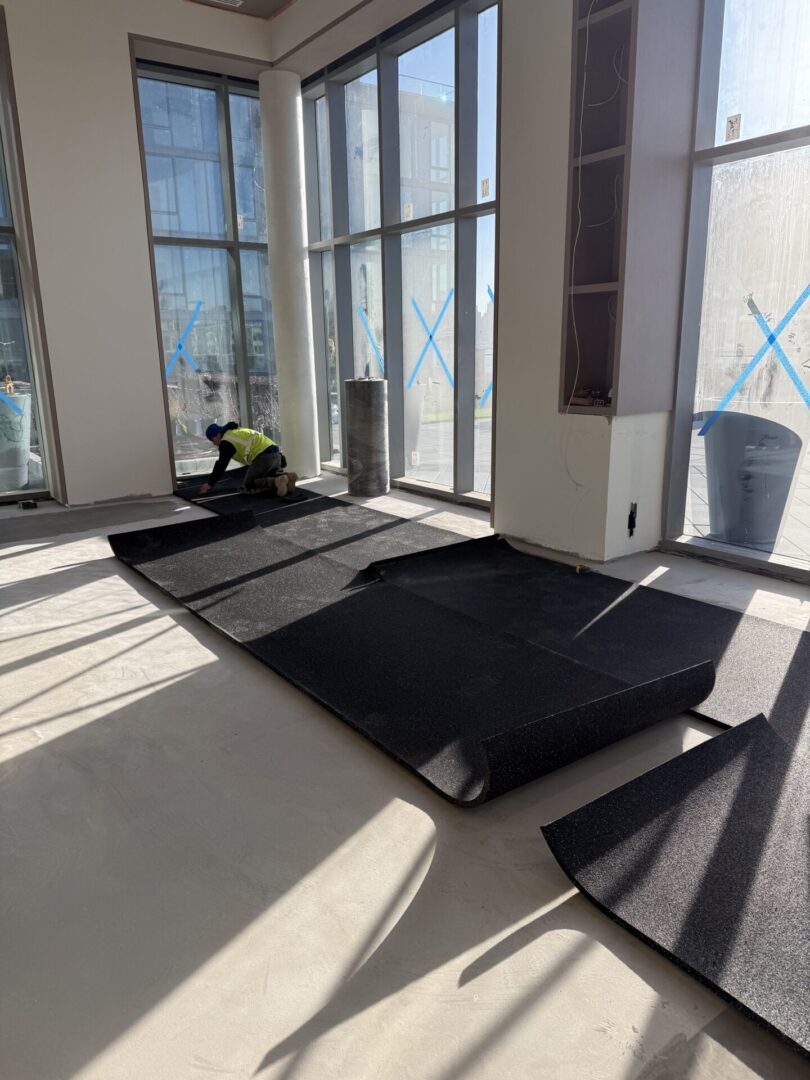 A room with several windows and a black mat.