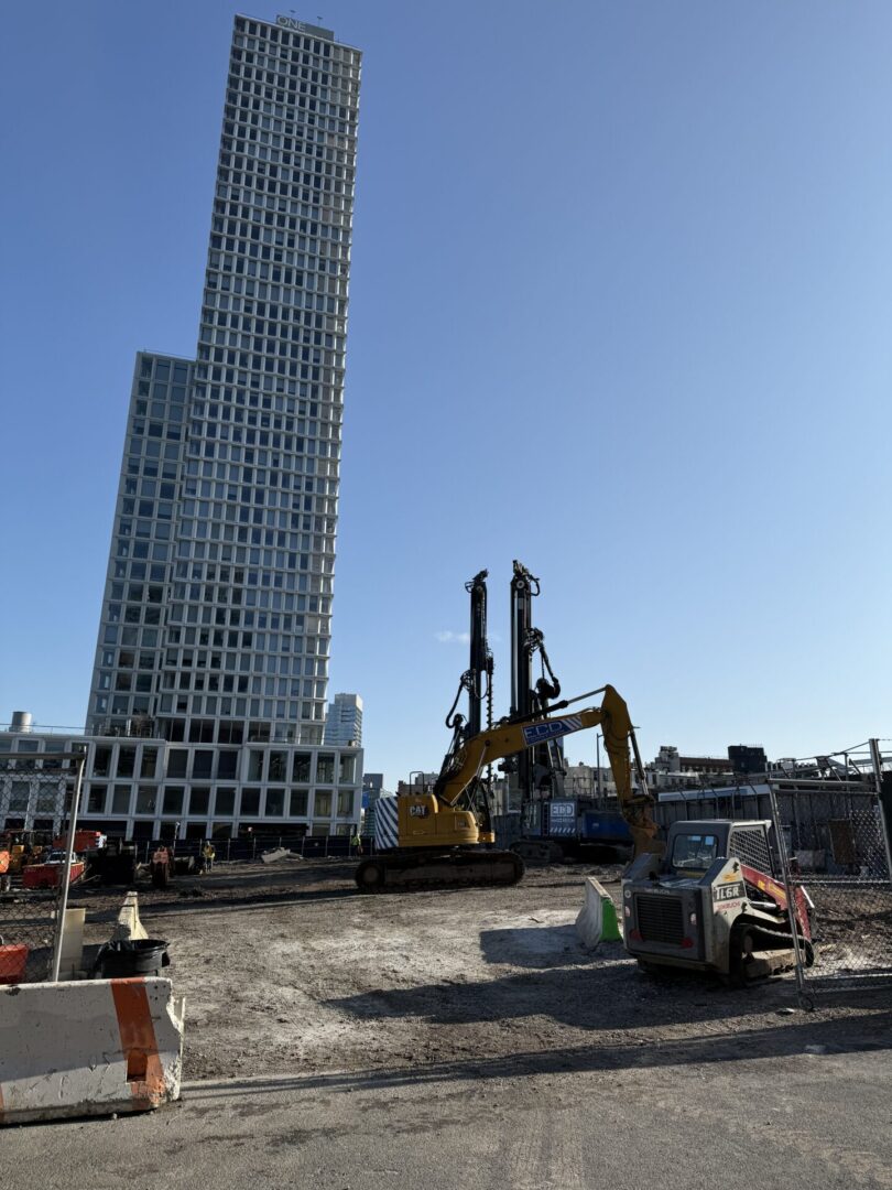 A construction site with cranes and machinery in the foreground.