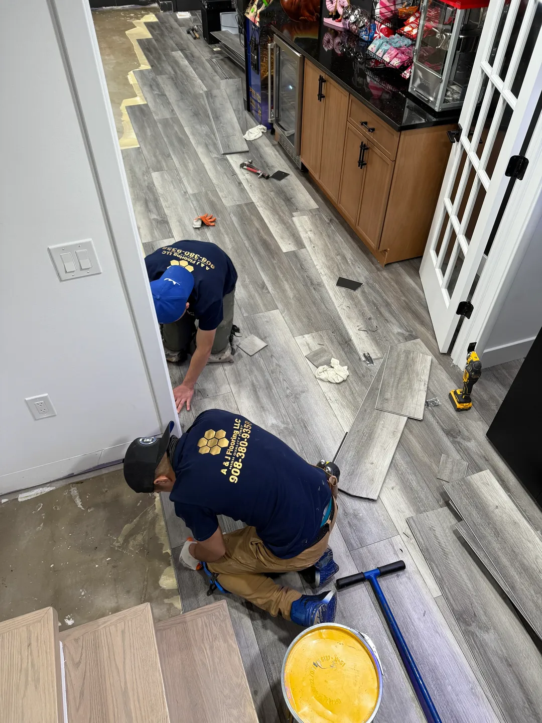 rs=w_1440,h_1440 Two men working on a floor in the kitchen.